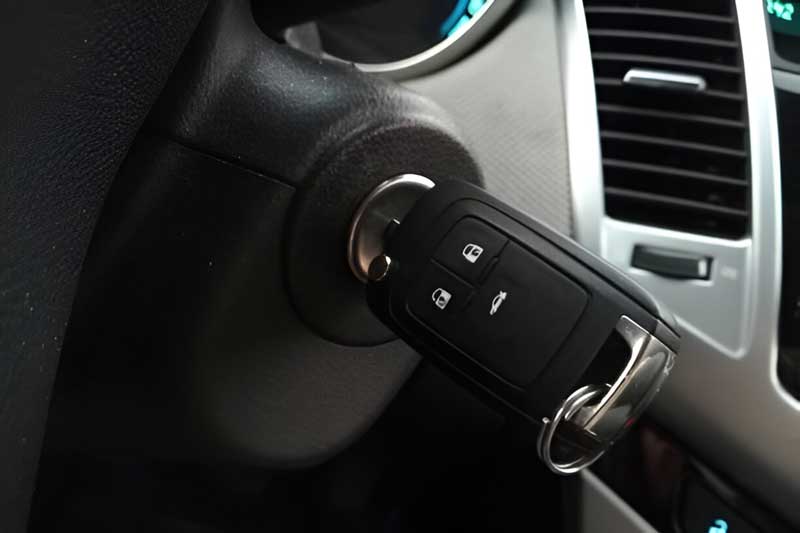 Car ignition with a modern key fob inserted, highlighting automotive locksmith services related to key manufacturing and ignition system repairs.