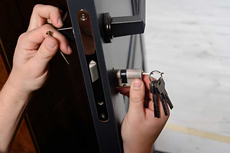 Hands installing a residential lock with keys, showcasing professional locksmith services for home security.
